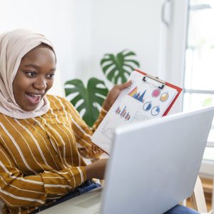 Focused muslim businesswoman presenting charts and graphs on video call online. Young business woman ih hijab having conference call with client on laptop. working laptop computer indoor.